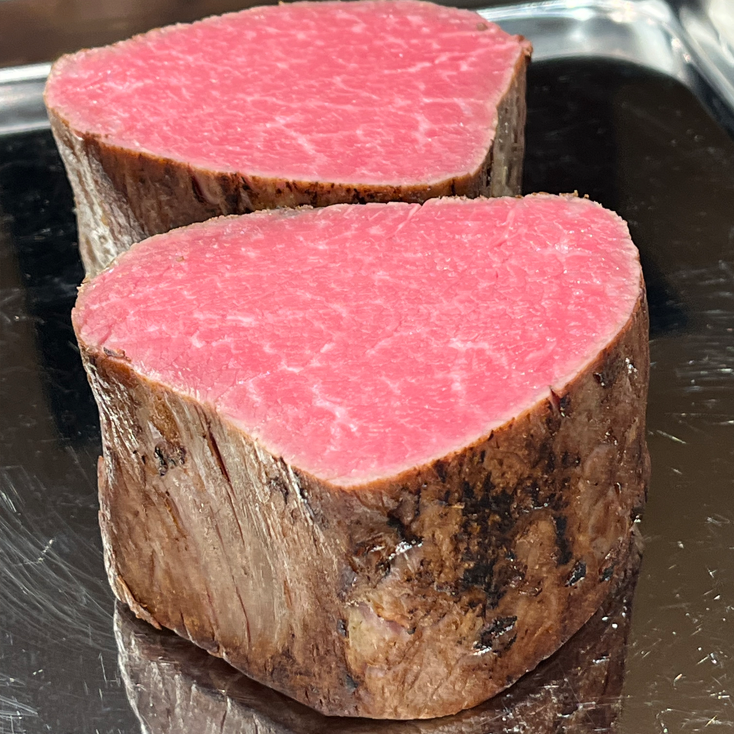 バットに置いた御嘉 但馬牛ローストビーフの塊。ロゼ色の断面