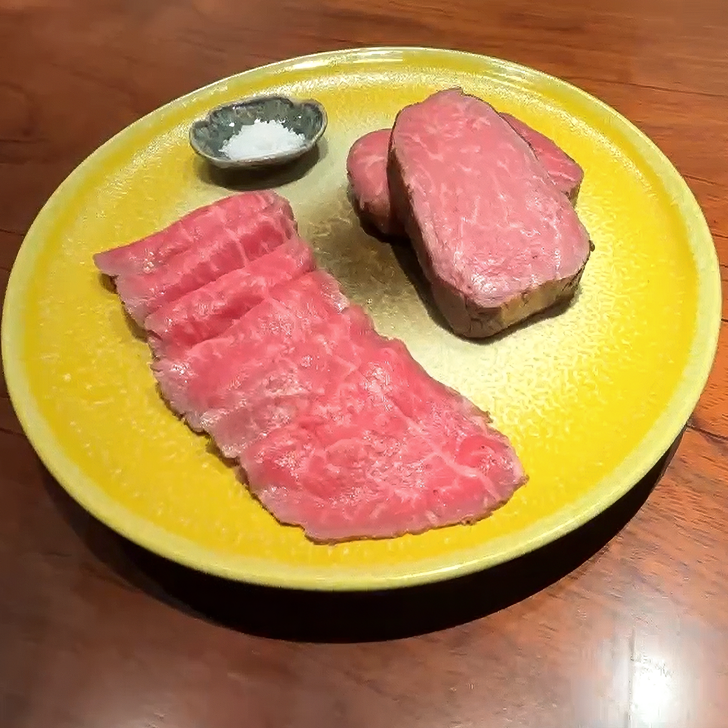御嘉 但馬牛ローストビーフの盛り付け。黄色い器に薄切りと厚切りを並べ、天日塩フロール・デ・サルを添えて